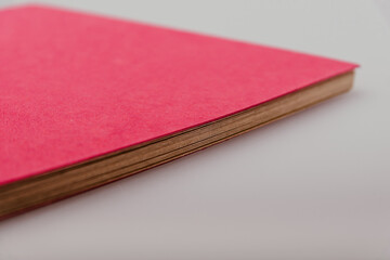 Bright magenta colour craft paper photo album with spiral binding on a white studio background. DIY scrapbooking, storing printed photos. Multiple angles of eco-friendly designed notebook