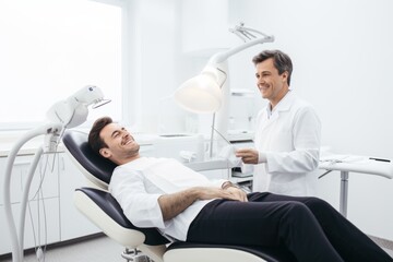 Obraz premium A man relaxes in a dental chair, chatting with the dentist