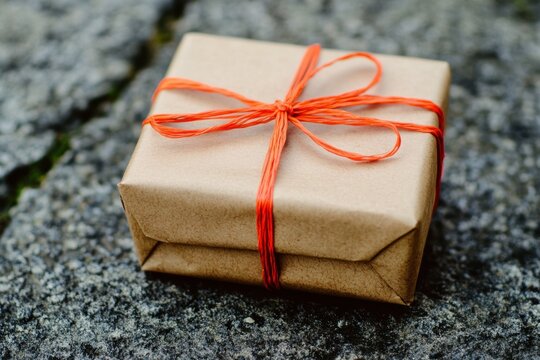 Simple wrapped gift with orange string on textured background