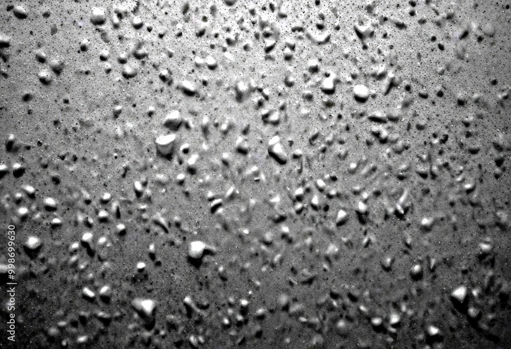 Aufkleber a close-up view dark, textured surface with numerous small, irregularly shaped droplets scattered across it, creating a sense of depth and complexity