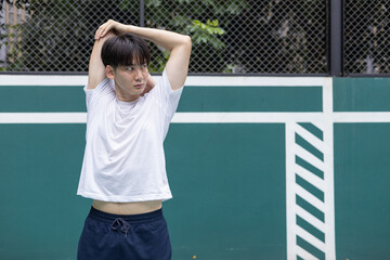 Young Athlete Stretching on Outdoor Basketball Court