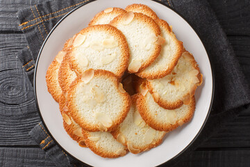 French delicacy pastry tuile with almond closeup on the plate on the table. Horizontal top view from above