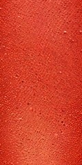 a close-up view textured surface with a vibrant red color, resembling a water droplet pattern