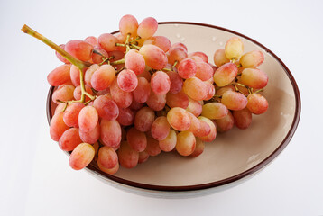 A juicy beautiful bunch of grapes lies in a plate.