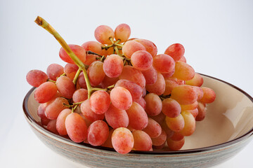 A juicy beautiful bunch of grapes lies in a plate.