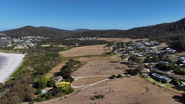 Dry land near the seaside and suburban neighborhood during daytime, aerial shot