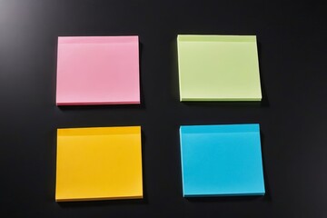 Fototapeta premium four different colored sticky notes are placed on a black surface