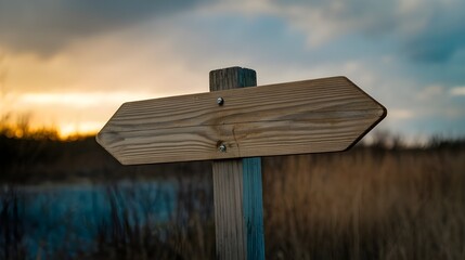 Wooden Arrow Signpost at Sunset with Grassy Field