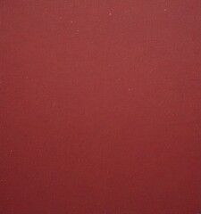Fototapeta premium a close-up view red fabric surface, with a slight texture and a few small white specks scattered across it