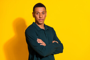 Photo portrait of attractive young man crossed hands confident dressed stylish green clothes isolated on yellow color background