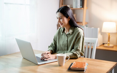 Creative young woman working on laptop in her studio