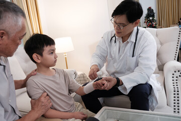 Obraz premium The doctor treats a wound on a boy's arm at home