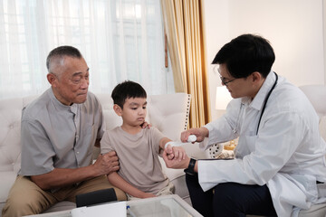 Obraz premium The doctor treats a wound on a boy's arm at home