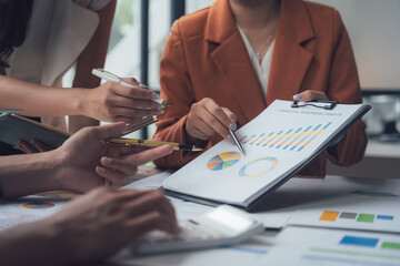 Business Strategy: A diverse team of business professionals collaborate over financial data,...