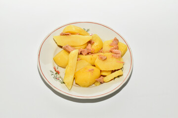 Stewed potatoes with meat lie on a plate. Top view.