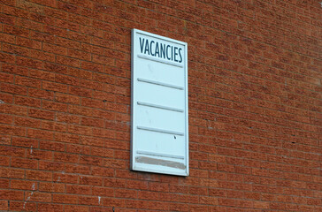 Unused 'Vacancies' Sign on Outdoor Brick Wall 