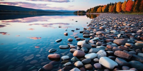 A tranquil seashore at sunset with colorful skies reflecting on the calm water surrounded by trees