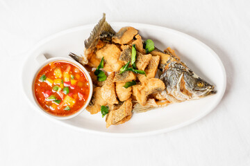 Fried sea bass on a white plate, looks delicious.