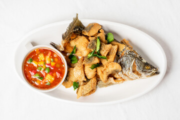 Fried sea bass on a white plate, looks delicious.