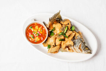 Fried sea bass on a white plate, looks delicious.