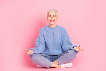 Full length photo of pretty retired female sit floor meditation wear trendy blue knitwear outfit isolated on pink color background