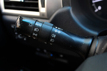 Low and high beam switch. Black light switch lever of an SUV vehicle. Car left or right turn signal...