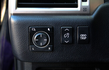 Obraz premium Rear view mirror adjustment panel. Car window lifter buttons close-up. Front and back electric windows buttons-lower or close car windows. Modern car interior.