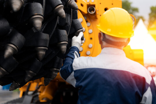 Industry operator use computer tablet for control and diagnostics drilling head of mine roadheader. Concept underground mining of coal and ore.