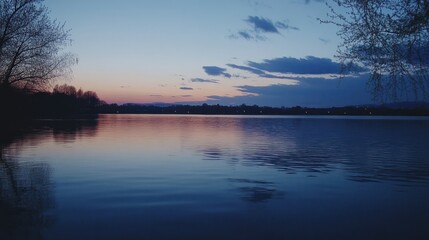 Fototapeta premium Tranquil lake at dusk with a pink sky and silhouette trees