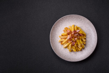 Crispy French fries with pieces of bacon, salt and spices