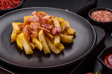 Crispy French fries with pieces of bacon, salt and spices