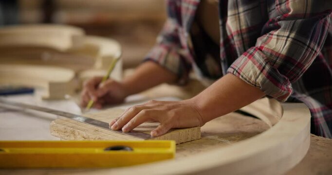 Carpenter, hands and pencil with ruler for construction notes, furniture or project plans. Closeup of person measuring wood for tools in a creative carpentry workshop for manufacturing, art and craft