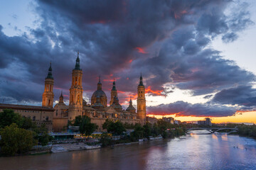 Obraz premium Basílica del Pilar de Zaragoza atardeciendo desde puente de piedra