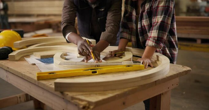 Carpenter, measurement and pencil with partners for construction, furniture or project. Closeup of people marking wood with tools in a creative carpentry workshop for manufacturing, art and craft
