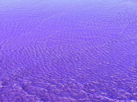 Purple water rippled surface aqua background.