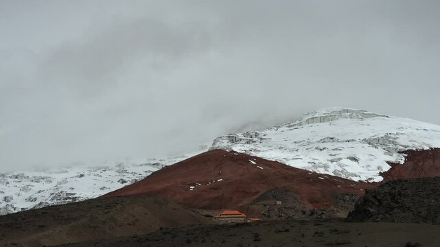 Refuge building with snowy Cotopaxi volcano in background, Andes in Ecuador. Static view and sky for copy space
