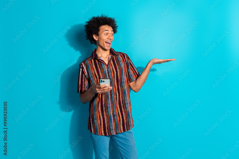 Canvas Prints Portrait of nice young man hold phone empty space wear shirt isolated on turquoise color background