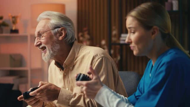 Elderly nursing home patient and woman nurse playing video games, having fun