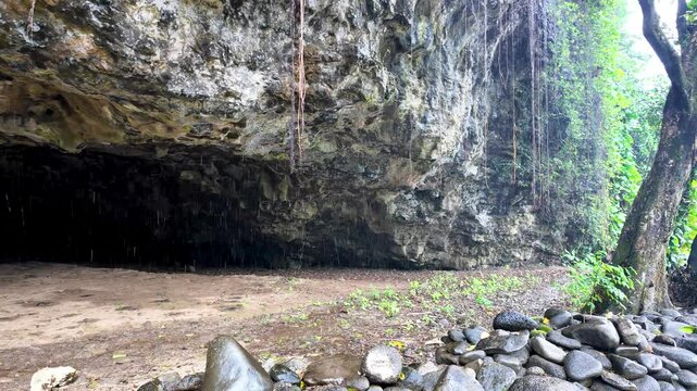 View from outside of Maniniholo Dry Cave located near Haena Beach Park, under a large cliff, Kauai, Hawaii this cave offers a sandy floor, low ceilings and the lore of an evil spirit.