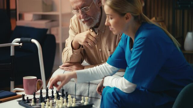 Retirement home male patient playing chess with young carer, training his memory