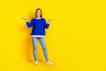 Photo of model young cheerful woman in blue stylish pullover and jeans balance compare two projects isolated on yellow color background
