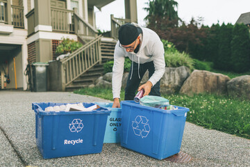 A man sorting the recycling bins at home. 