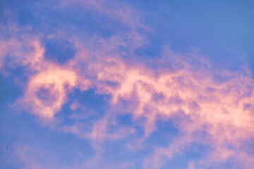 A beautiful sky tinted by the sun leaving vibrant shades of gold, pink, blue and multicolored. Clouds in the twilight evening and morning sky. Cloudy sky background in the evening, and during the day.