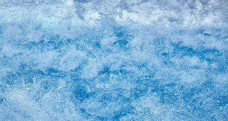 Struktur von sprudelndem Wasser hinter einer Glasscheibe