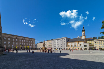 Naklejka premium Clouds hover over the main square in Salzburg filled with tourists beating the sun, Salzburg, Austria