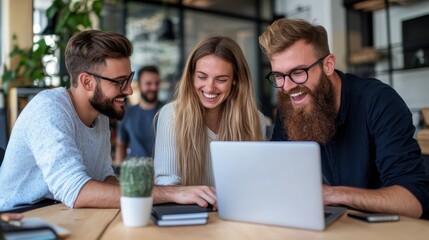 A close-knit team gathers around a laptop, smiling and laughing, showcasing camaraderie and enthusiastic teamwork in a bright, fashionable office environment.