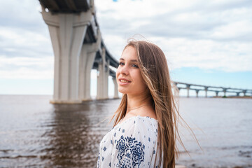 Rear view of a young girl looks on western high-speed diameter from Kanonersky Island in St....