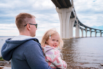 Rear view of a man with little child look on western high-speed diameter from Kanonersky Island in...