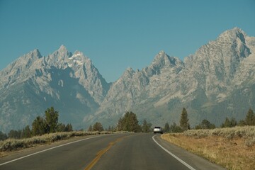 Car driving on highway through the Grand Teton Mountains in Grand Teton National Park