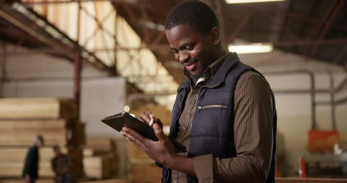 Carpenter, man and woodwork in workshop with tablet for digital checklist, timber inventory count and online order. Carpentry, black worker and planning in factory for ecommerce and quality assurance